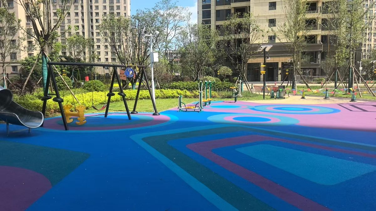 EPDM rubber safety surface in a low age play zone with a rope climbing frame and low slide EPDM rubber safety surface in a low age play zone with a rope climbing frame and low slide