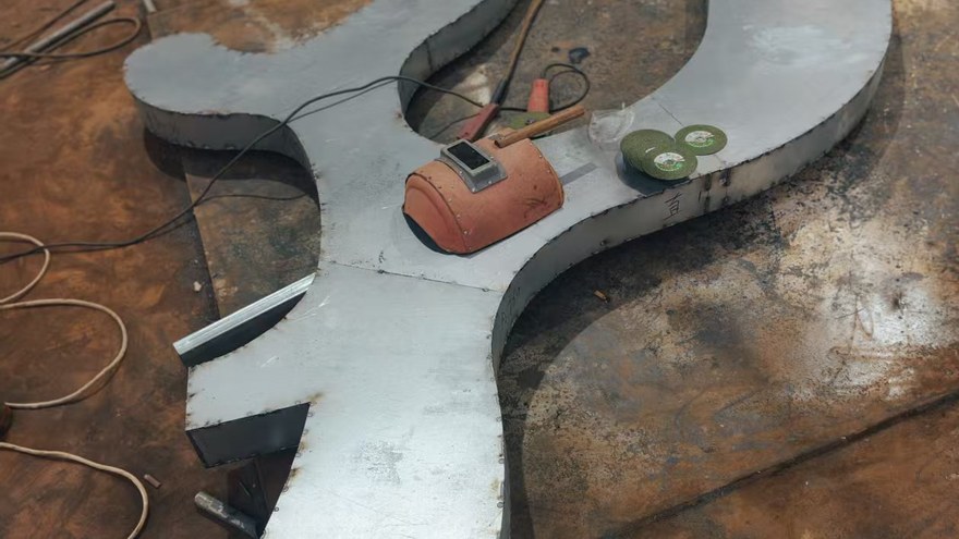 steel plate cut to shape on a workshop floor during playground part preparation