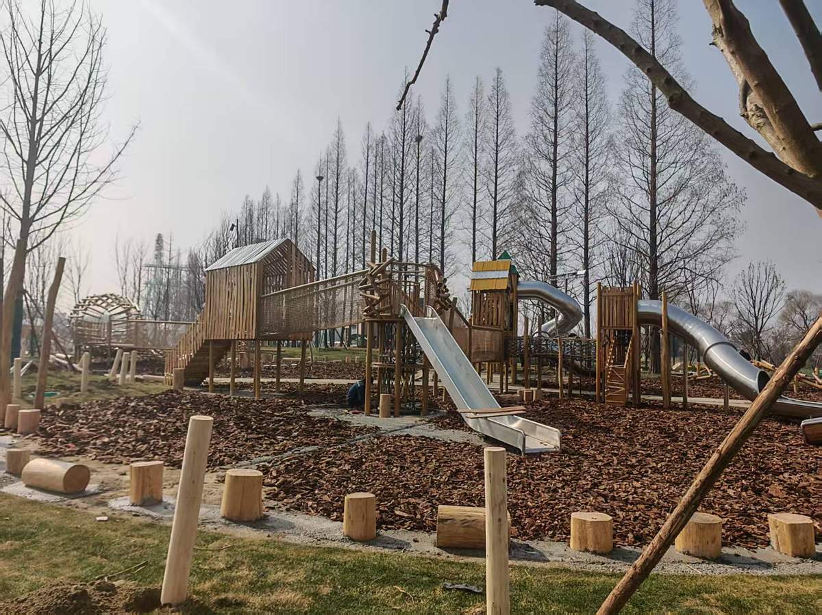 low timber play tower with stainless steel slides set inside a wood chip surfacing area for children under six low timber play tower with stainless steel slides set inside a wood chip surfacing area for children under six